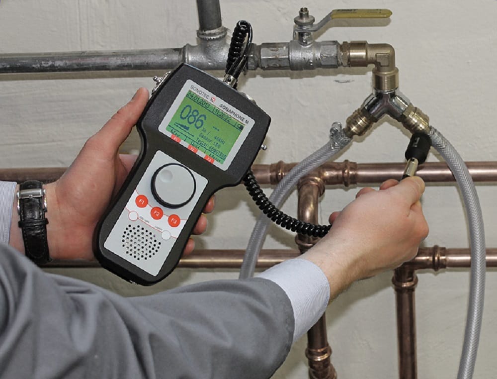 Plumber testing pipes with electronic leak detection equipment in St. Petersburg