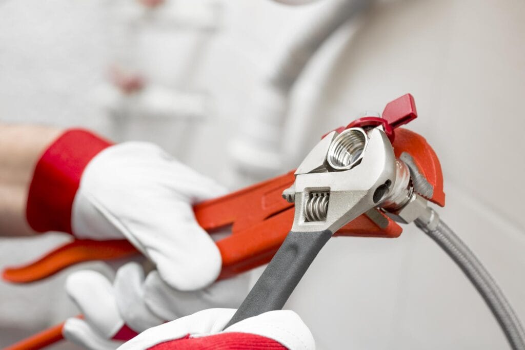 Plumber holding pipe wrenches for an emergency repair in St. Petersburg