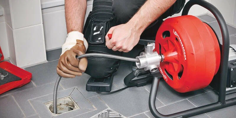 Plumber using a drain-cleaning machine in St. Petersburg