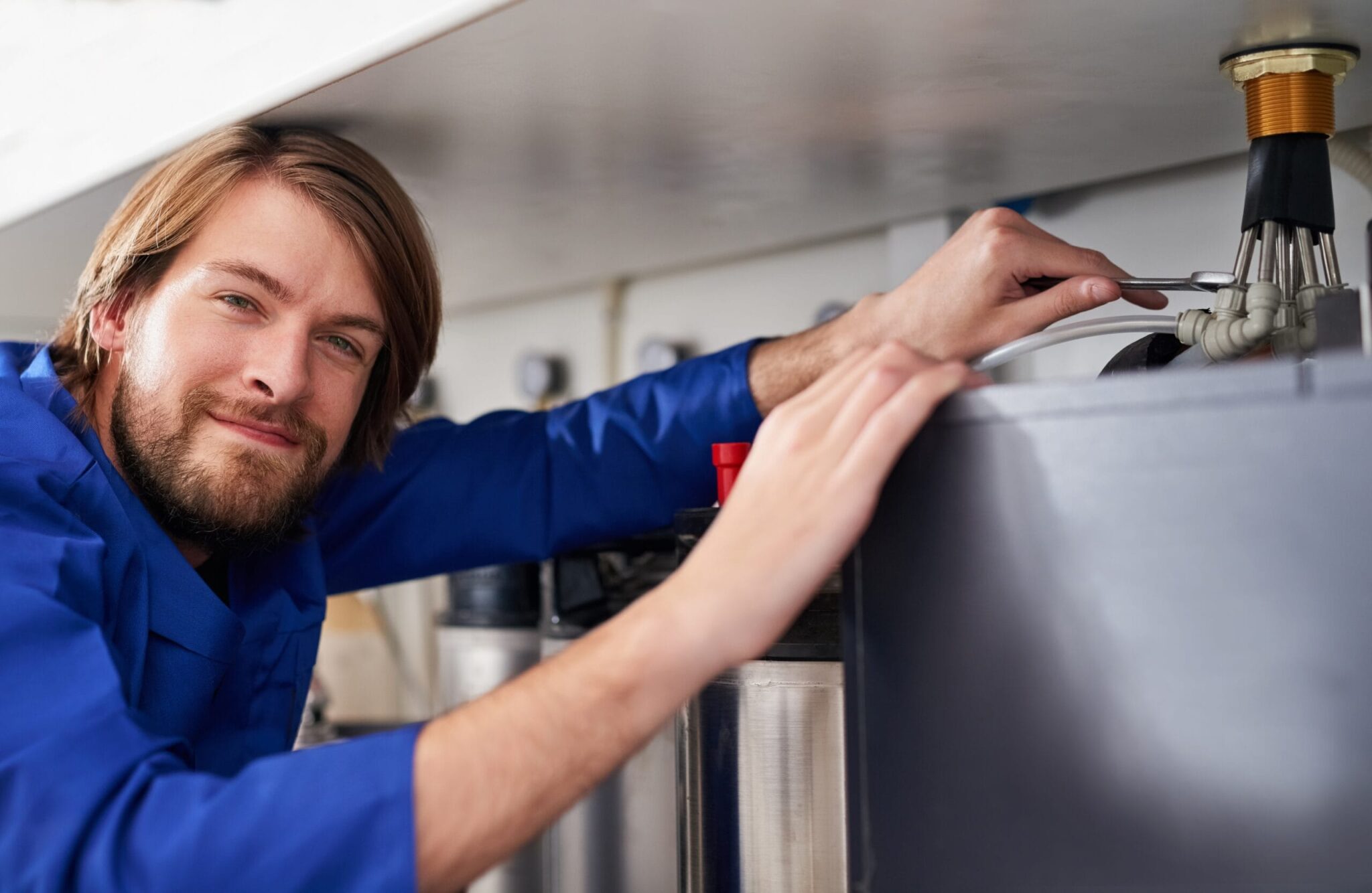 Technician servicing a residential water heater tank in St. Petersburg