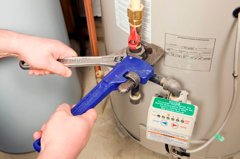 Plumber repairing a water heater valve in St. Petersburg